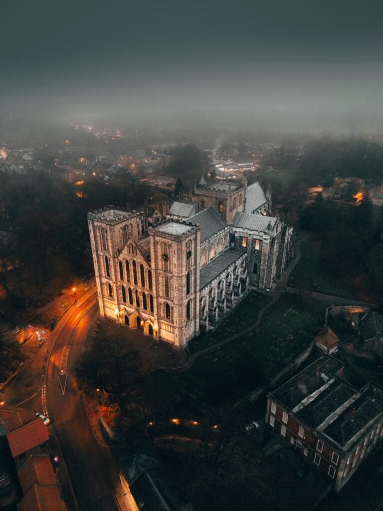 Dramatic aerial photo of Ripon Cathedral surrounded by foggy night ambiance.